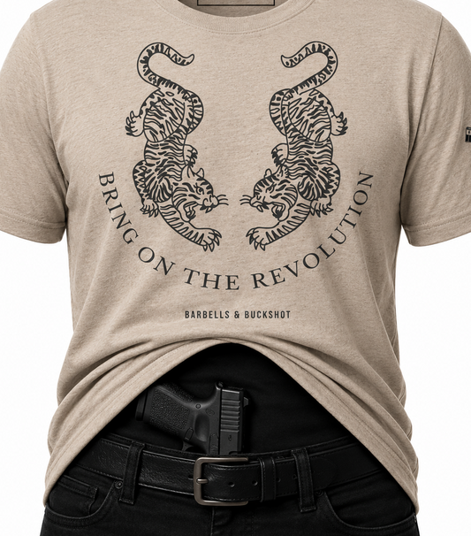 Beige t-shirt with tiger design and text, worn by a person with a gun holster.